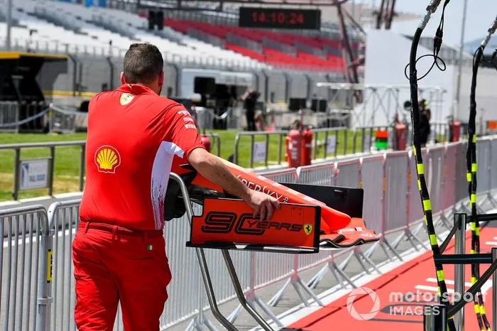 Mecánico de Ferrari empujando el alerón delantero de un Ferrari SF90 