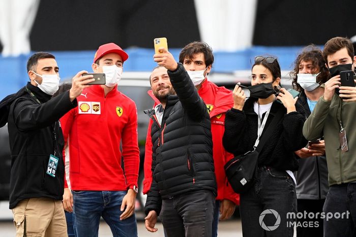 Charles Leclerc, de Ferrari, y Carlos Sainz Jr., de Ferrari, posan con los aficionados para un selfie a su llegada al circuito 