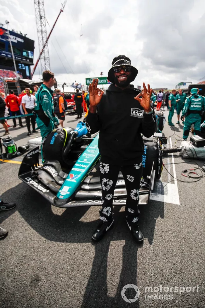 El rapero Tinie Tempah en la parrilla con el coche de Fernando Alonso, el Aston Martin AMR23