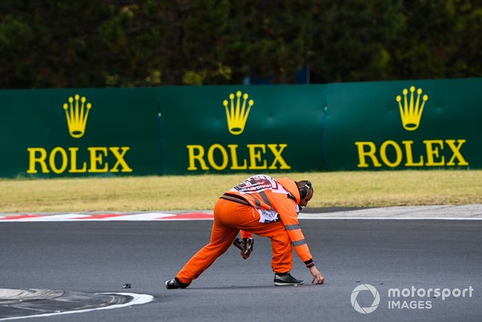 Un comisario retira algunos restos del circuito