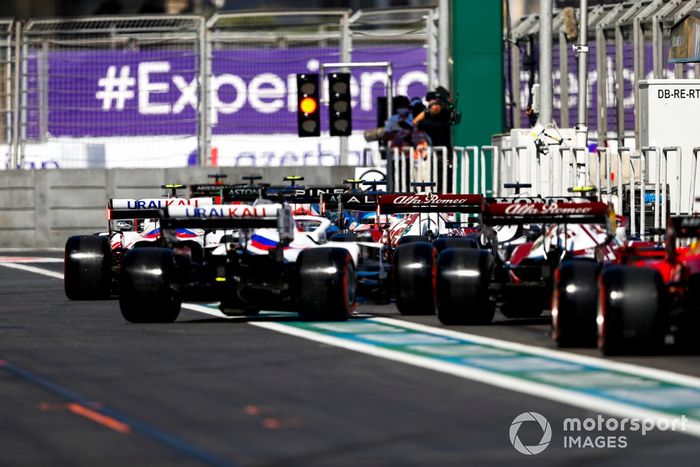 Los monoplazas en fila para salir de pits