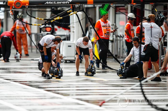 Mecánicos de McLaren secando el suelo