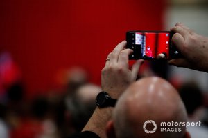 Un fan toma una fotografía de Charles Leclerc siendo entrevistado en el escenario de Autosport