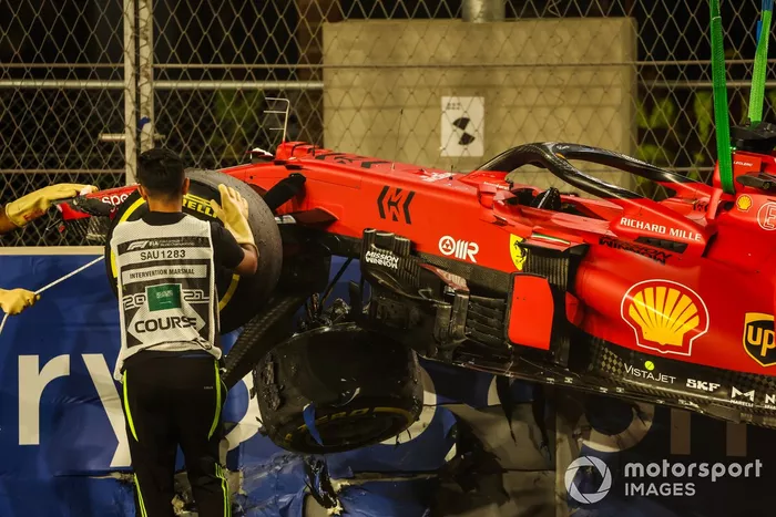 Los oficiales de pista retiran el coche de Charles Leclerc, Ferrari SF21, del circuito