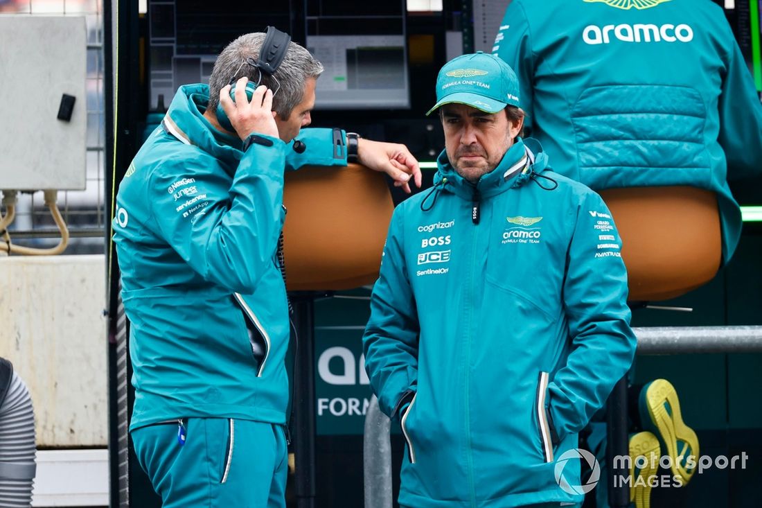 Fernando Alonso, Aston Martin F1 Team, habla con un compañero de equipo en el pit lane 