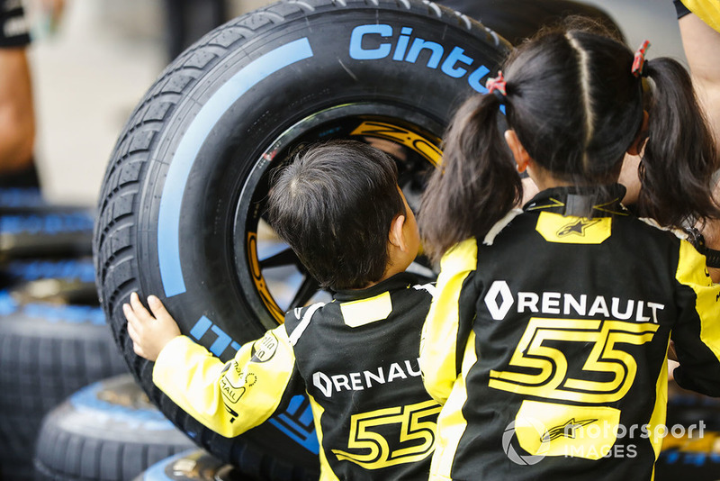Young fans check out the Pirelli tyres of the Reanult team.