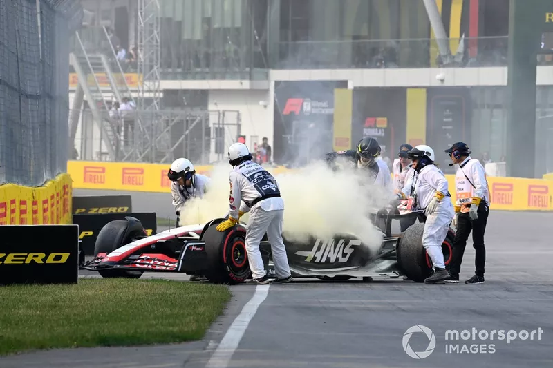 I commissari tentano di spegnere un incendio sulla vettura di Nico Hulkenberg, Haas VF-23