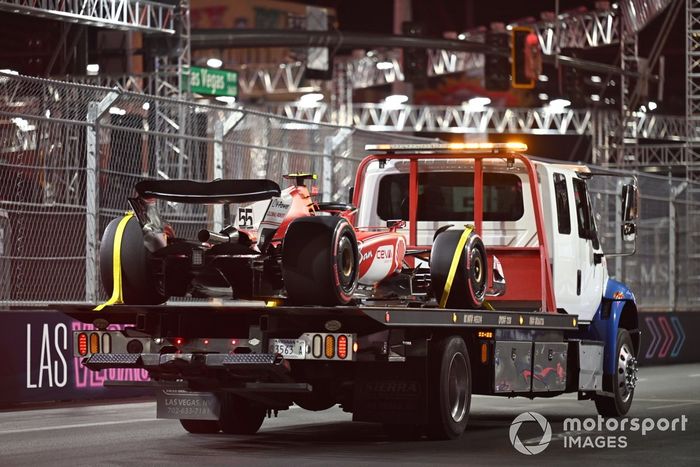 El coche de Carlos Sainz, Ferrari SF-23, regresa a boxes tras los daños causados por una tapa de alcantarilla