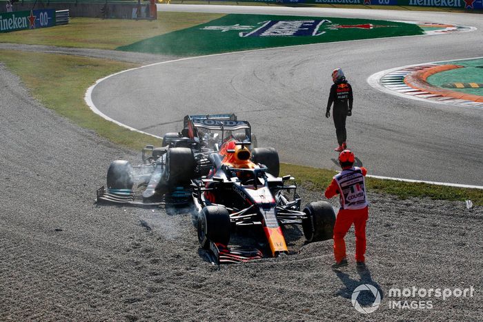 Max Verstappen, Red Bull Racing, se aleja mientras un oficial de pista asiste en el lugar de su accidente con Lewis Hamilton, Mercedes W12