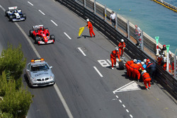 The Renault R24 of Fernando Alonso is recovered by marshalls after crashing out of the tunnel as Michael Schumacher, Ferrari F2004 follows the safety car ahead of Juan Pablo Montoya, Williams BMW FW26