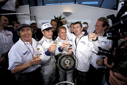 Jackie Stewart, Paul Stewart, and the Stewart team celebrate their first win for Johnny Herbert, and