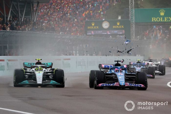 Los escombros vuelan mientras Lewis Hamilton, Mercedes W13, lucha con Fernando Alonso, Alpine A522