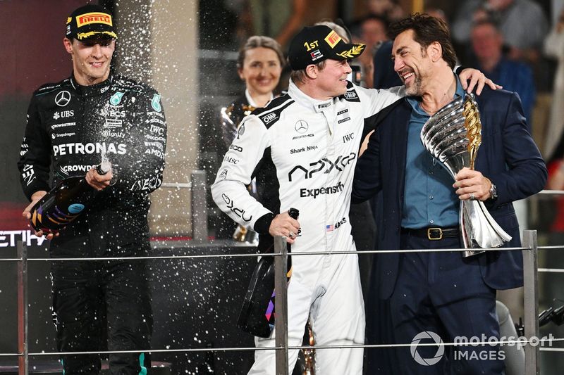 George Russell, Mercedes-AMG F1 Team, Brad Pitt y Javier Bardem ruedan una escena para la película de F1 en el podio.

