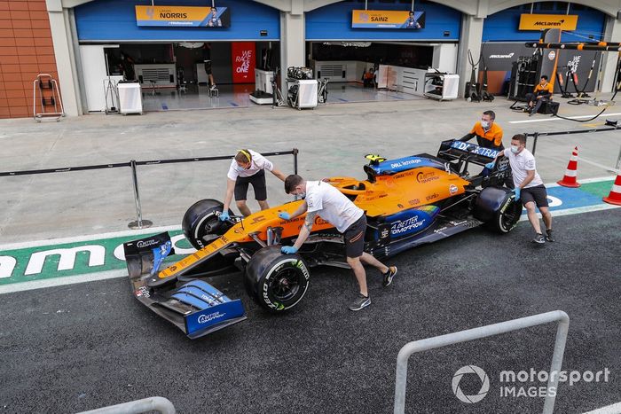 Mecánicos de McLaren llevan el coche por el pitlane de Turquía