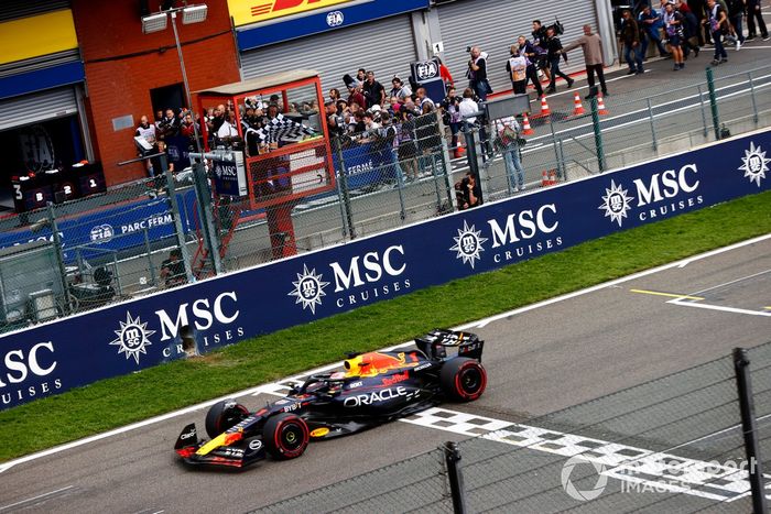 Max Verstappen, Red Bull Racing RB19, 1ª posición, toma la bandera a cuadros