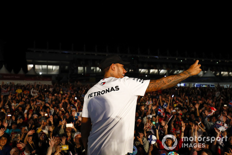 Lewis Hamilton, Mercedes AMG F1, takes a photo with the crowd from the stage