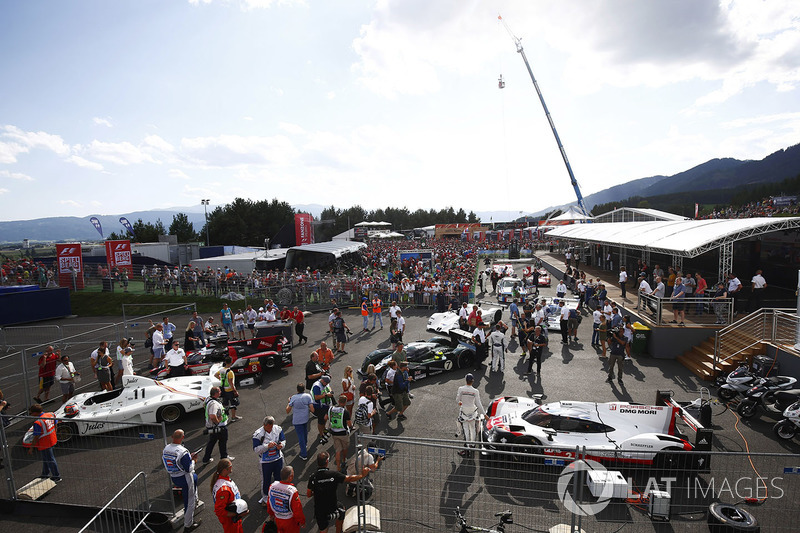 A gaggle of sportscars. In the foreground are a Jules sponsored Porsche 936 and modern Porsche 919