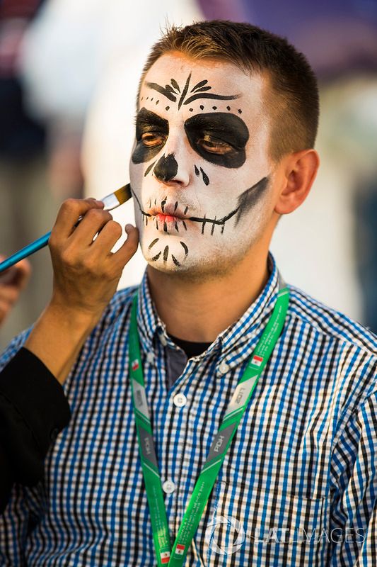 Caras pintadas del día de muertos a personas en el paddock