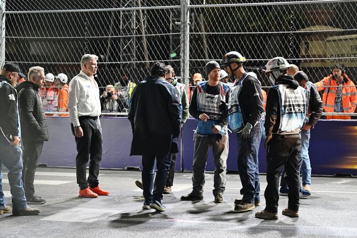 Marshals and circuit staff gather to repair a drain cover on track which caused a red flag 