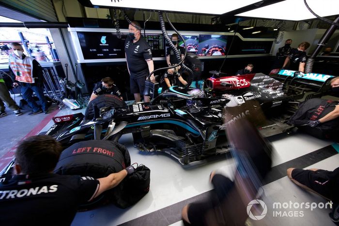Los mecánicos retiran los calentadores de neumáticos de Lewis Hamilton, Mercedes W12, en el garaje