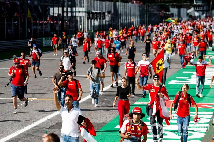 Tifosi storm the track with a Ferrari flag