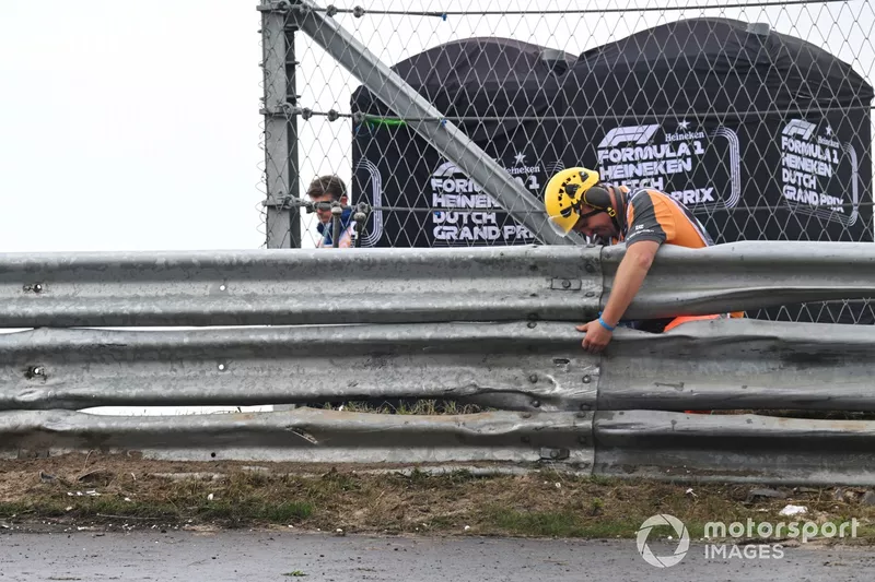 Un commissaire inspecte une section de la barrière Armco après l'accident de Logan Sargeant, Williams FW46.