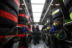 Un mécanicien Haas F1 Team au travail dans le garage, entouré de pneus Pirelli