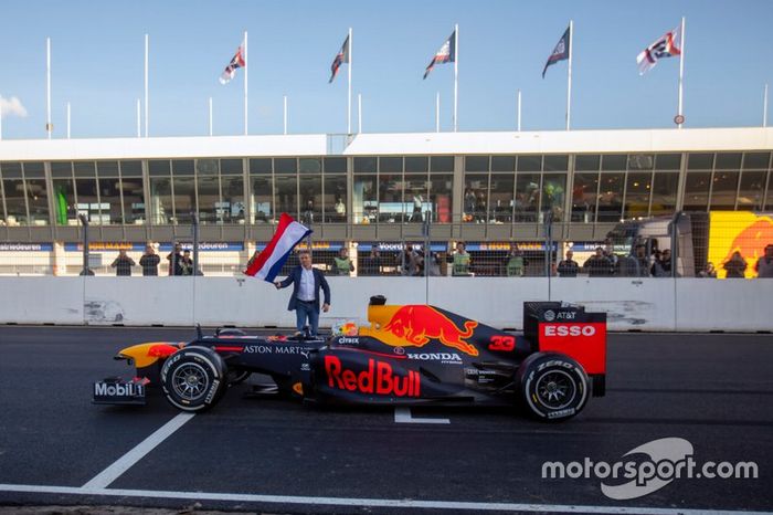 Max Verstappen, RB8, en la recta principal del circuito de Zandvoort con Jan Lammers con la bandera de Holanda