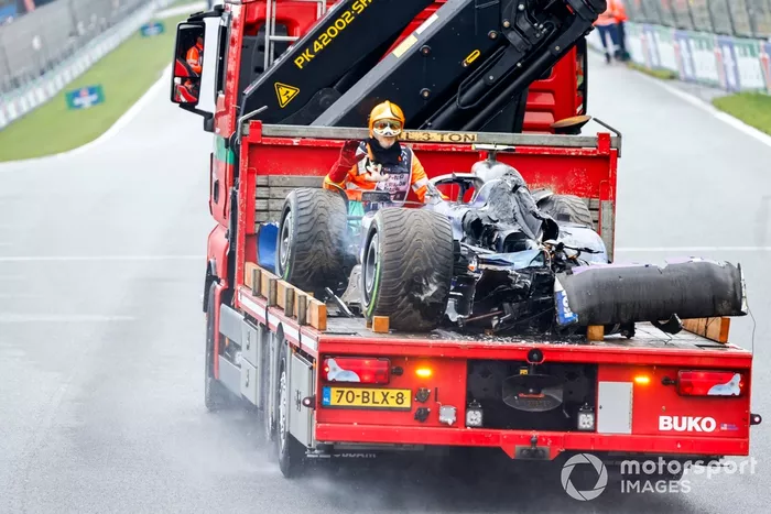 Un comisario con el coche dañado de Logan Sargeant, Williams FW46, en un camión