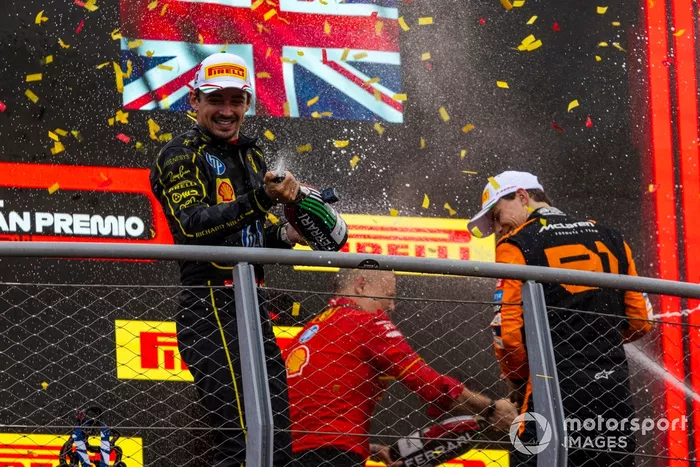 Charles Leclerc, Scuderia Ferrari, 1ª posición, Oscar Piastri, McLaren F1 Team, 2ª posición, rocío de champán en el podio.