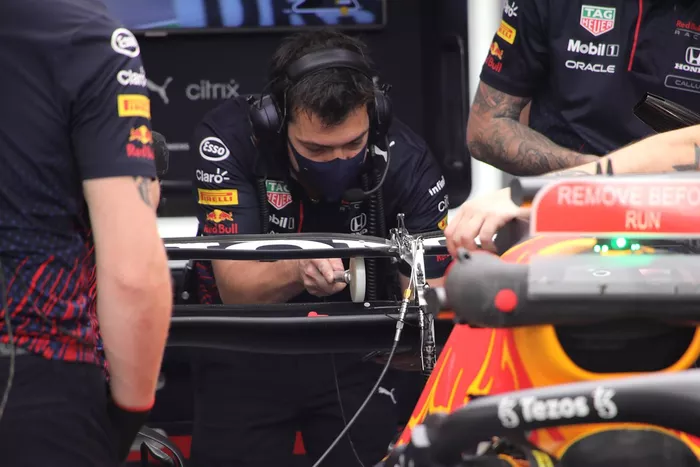 Miembros de Red Bull Racing revisan el alerón trasero del RB16B