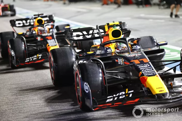 Sergio Pérez, Red Bull Racing RB19, adelanta a Max Verstappen, Red Bull Racing RB19, en boxes.