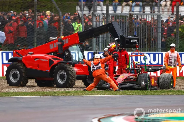 Los oficiales asisten a Carlos Sainz Jr., Ferrari F1-75, en la grava