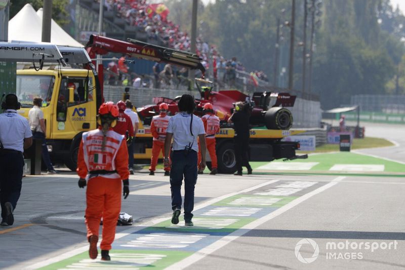 Los comisarios con el coche accidentado de Carlos Sainz Jr., Ferrari SF21