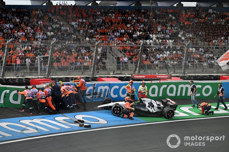 I commissari riparano le barriere e si occupano della vettura danneggiata di Daniel Ricciardo, AlphaTauri AT04