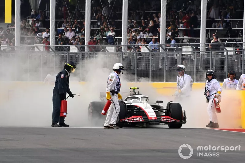 I commissari tentano di spegnere un incendio sulla vettura di Nico Hulkenberg, Haas VF-23