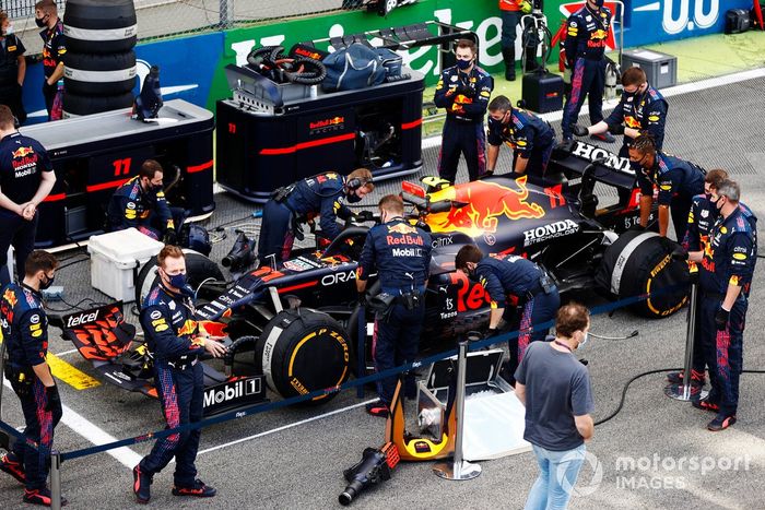 Mecánicos en la parrilla con el coche de Sergio Pérez, Red Bull Racing RB16B