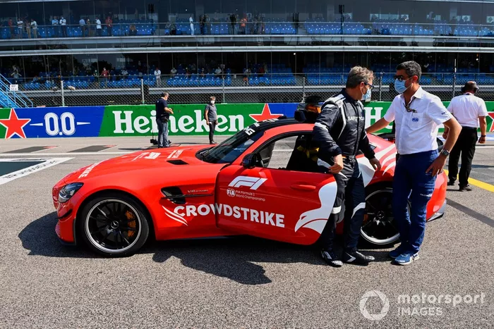 Bernd Maylander, piloto del coche de seguridad, y el coche de seguridad en la parrilla con Michael Masi, director de carrera de la FIA