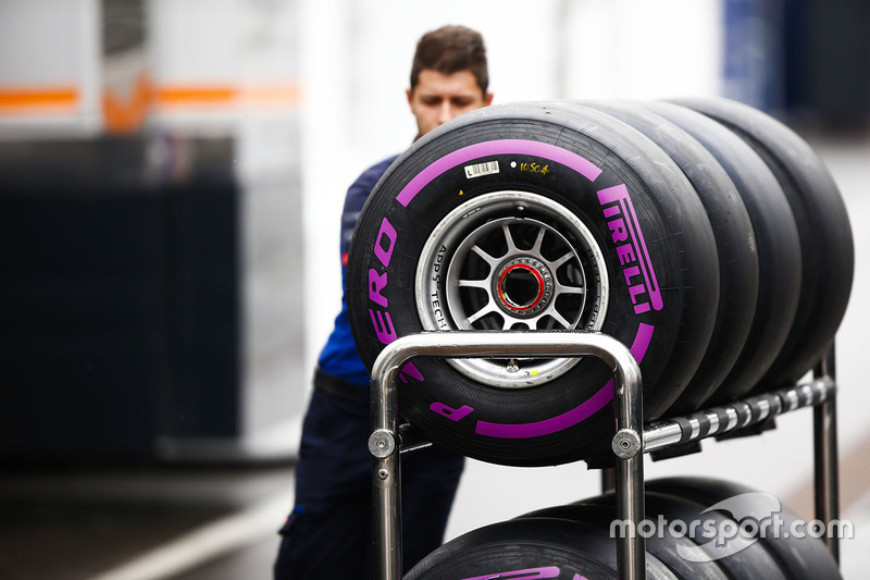 Un membro di un team attraversa il paddock con degli pneumatici Pirelli