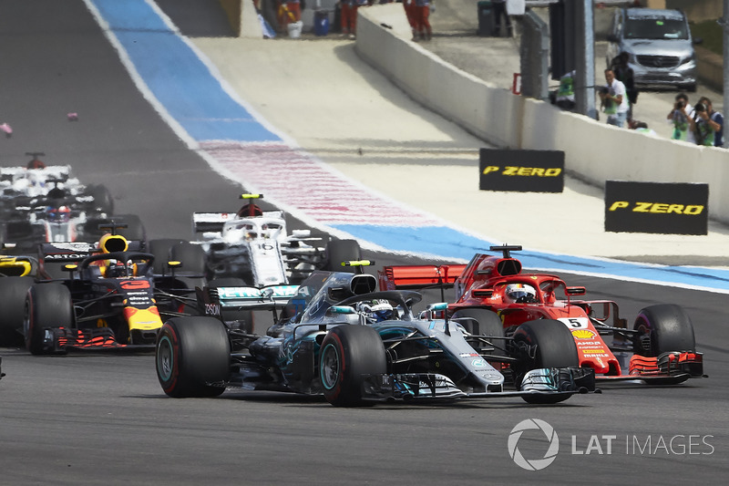 Valtteri Bottas, Mercedes AMG F1 W09, con Sebastian Vettel, Ferrari SF71H, en la salida