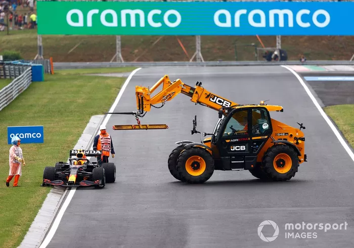 Los oficiales de pista retiran el coche dañado de Sergio Pérez, Red Bull Racing RB16B