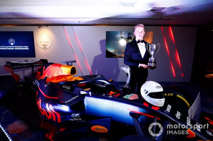 Il vincitore dell'Aston Martin Autosport BRDC Young Driver Award Johnathan Hoggard festeggia con gli amici e la famiglia con il trofeo e l'assegno vicino alla Red Bull Racing RB15