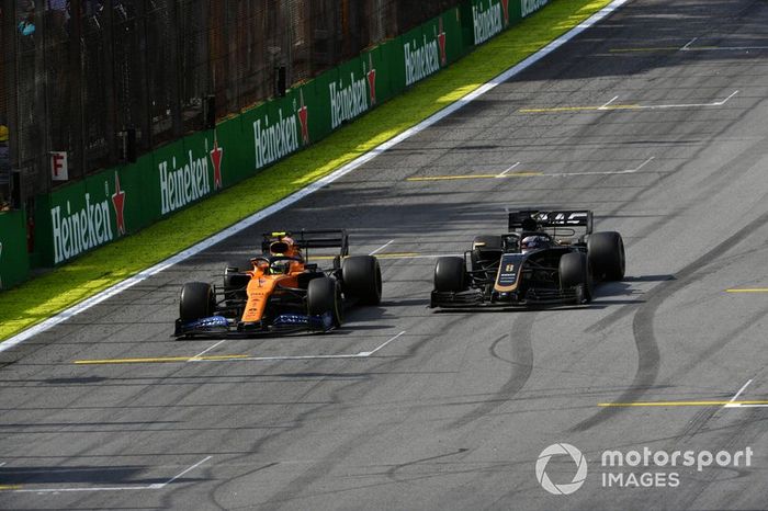 Lando Norris, McLaren MCL34, pasa a Romain Grosjean, Haas F1 Team VF-19
