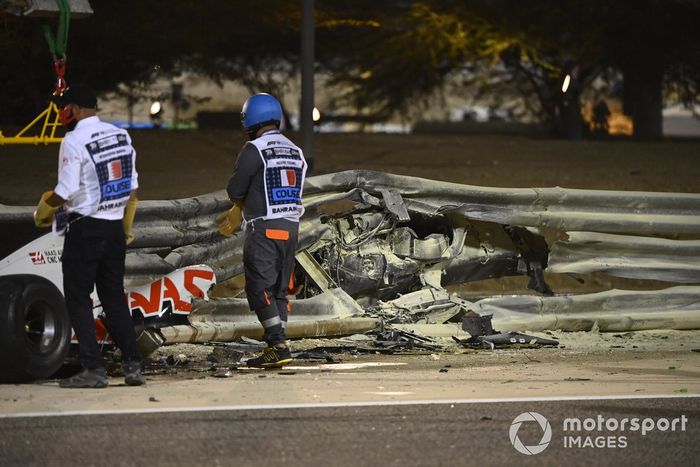 The wrecked car of Romain Grosjean, Haas VF-20, and damaged Armco after a big crash on the opening lap