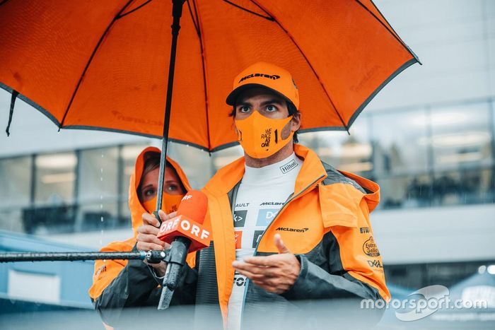 Carlos Sainz Jr, McLaren, se refugia bajo un paraguas 
