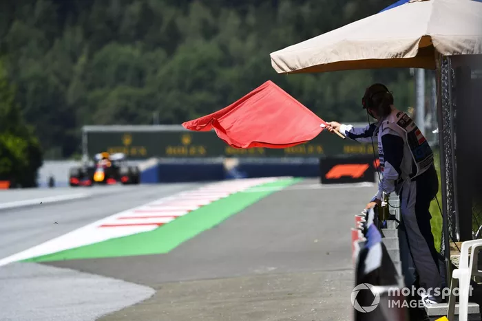 Un comisario con bandera roja al paso de Max Verstappen, Red Bull Racing RB16 