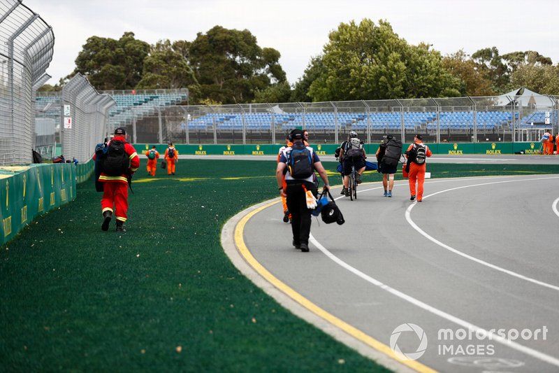 Los oficiales de pista dejan sus posiciones tras la noticia de que el evento es cancelado