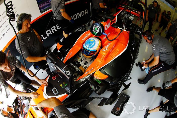 Fernando Alonso, McLaren, es atendido por mecánicos en su garaje
