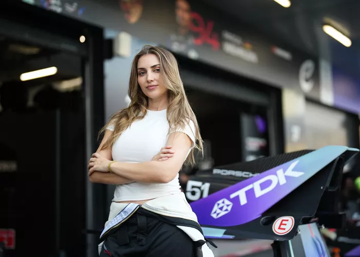 إميليا هارتفورد، سائقة فريق بورش فورمولا إي EVO Sessions، تقف لالتقاط صورة في منطقة الصيانة.