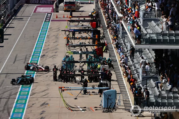 Fernando Alonso, Aston Martin AMR23 sale del box tras una parada en boxes mientras entra Nico Hulkenberg, Haas VF-23